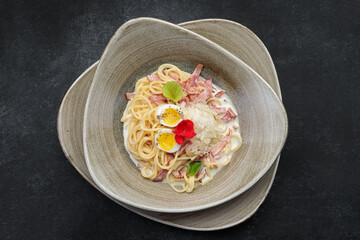 Spaghetti Carbonara on a plate, on a dark background