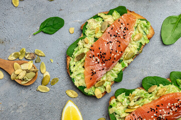 Delicious breakfast or snack sandwich salmon, avocado, spinach, nuts, sunflower seeds, toast with...