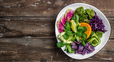 vegan salad with sweet potatoes, broccoli, avocado, purple cabbage, cucumber, watermelon radish and...