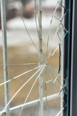 Glass broken by hooligans in a metal-plastic window, close-up - obrazy, fototapety, plakaty