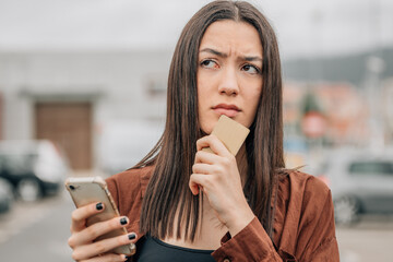 girl with mobile phone and card buying online