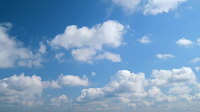 Spring clouds float across blue sky. Blue sky white clouds.