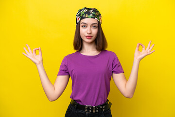 Young Ukrainian woman isolated on yellow background in zen pose