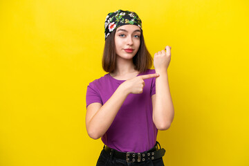 Young Ukrainian woman isolated on yellow background making the gesture of being late