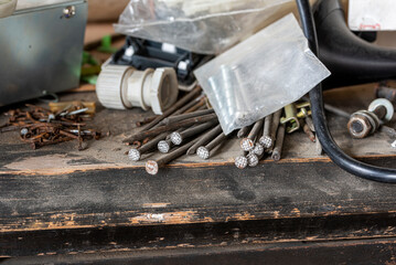 selective focus. a pile of steel nails on a dirty, dusty table