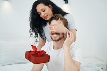 Romantic woman presenting gift to beloved person