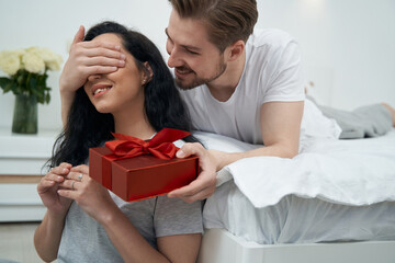 Fototapeta premium Loving man presenting gift to beloved woman