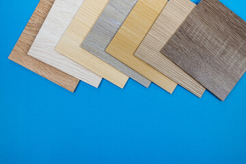 Laminate boards on blue. Samples of laminate or parquet with a pattern and texture of wood for...