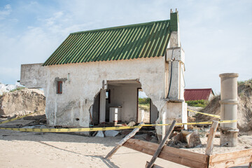 Fototapeta na wymiar Beach house destroyed by the storm and the ocean in Barra de Valizas, Uruguay