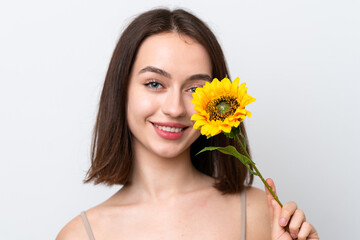 Young Ukrainian woman isolated on white background holding a sunflower while smiling. Close up portrait