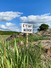 Danger, mines. War in Ukraine. Minefield. Sign caution stop mines in Ukrainian. Mined areas are...