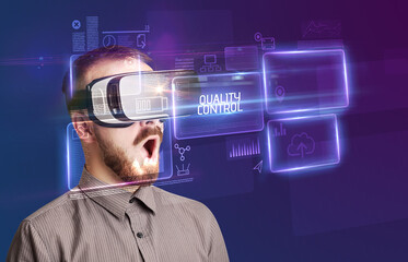 Businessman looking through Virtual Reality glasses, tech concept