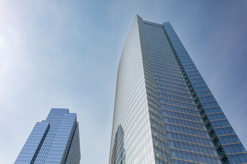 Fototapeta na wymiar Two modern glass skyscrapers on clear day in urban setting