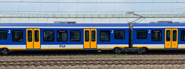 Weesp, the Netherland - June 5, 2022: Side view of a Dutch public transport train standing in a...