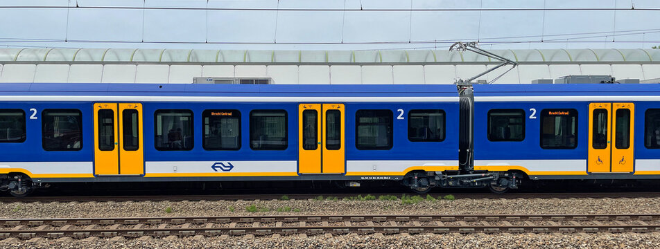 Weesp, the Netherland - June 5, 2022: Side view of a Dutch public transport train standing in a railway station.