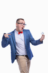 Young guy in a jacket, bow tie, glasses holds a condom in his hand. Isolated on white background