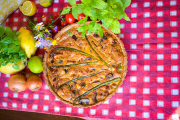 Quiche Lorraine Tart. Egg and cheese tart on pastry crust filled with savoury custard and pieces of cheese, bacon, and asparagus.