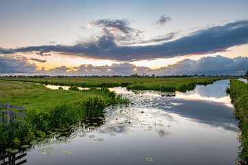 Beautiful clouds and calm water in the Dutch polder landscape at sunset