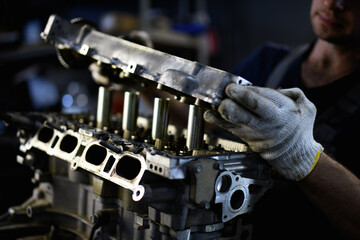 Partial shot of workman standing near damaged car engine in service 