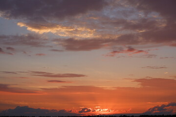 Red sunset landscape. Cumulus red clouds during sunset. Red clouds and blue sky at sunset.