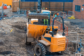 Construction plant and machinery. Dumper and excavator working on new homes construction site