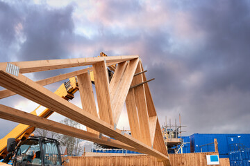 Heavy machinery shifting roof trusses on new residential housing development construction site - obrazy, fototapety, plakaty