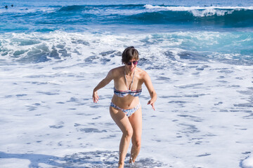 Girl has fun on the shore of the beach