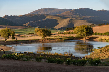 Caledon, Western Cape, South Africa. 2022. Evening light in the Overberg, a farm pond with a backdrop of the Riversonderend mountains. - Powered by Adobe