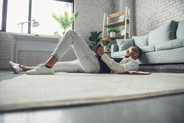 Caucasian man lying on back on the floor at home use tablet to talk on webcam video call. Internet communication, wireless connection technology.