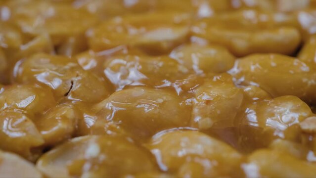 Macro: caramelized nuts fried in honey - Gozinaki - granola peanut bar on rotating surface - selective focus, close up. Traditional Georgian cuisine, oriental sweet, gastronomy and food concept
