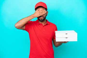 Pizza delivery Brazilian man with work uniform picking up pizza boxes isolated on blue background...