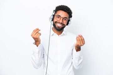 Telemarketer Brazilian man working with a headset isolated on white background making money gesture