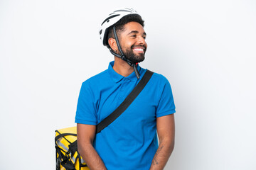 Young Brazilian man with thermal backpack isolated on white background looking side