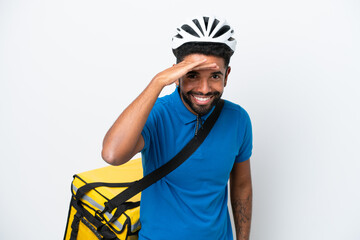 Young Brazilian man with thermal backpack isolated on white background looking far away with hand to look something