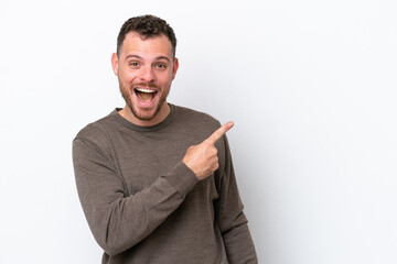 Young Brazilian man isolated on white background surprised and pointing side