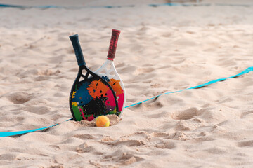 Fototapeta na wymiar Beach tennis rackets and balls on the beach sand