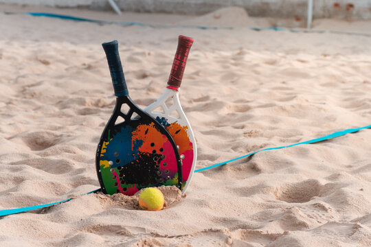 Beach tennis rackets and balls on the beach sand