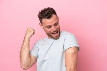 Obraz premium Young Brazilian man wearing a band-aids isolated on pink background celebrating a victory