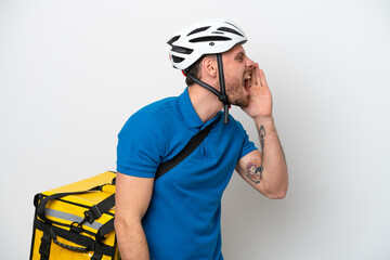 Young brazilian man with thermal backpack isolated on white background shouting with mouth wide open to the lateral