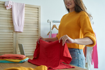 Close-up of beautiful young woman working in her own fashion store