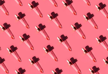 Pipette with gold metallic cap and drops of water, serum, oil, beauty product on pink background. Natural medicine, cosmetic research, bio science. Concept of skincare, analysis. Flat lay, pattern