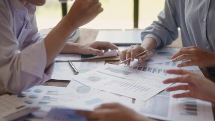 Closeup business people are working on their business. Discussed about paperwork that shows chat and graph of accounting statistics, number of cost. Busy teamwork makes success. Soft mood and focus.