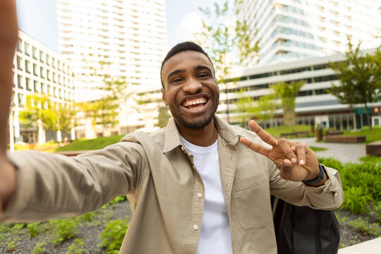 African american man takes a selfie, smiles on the background of the city