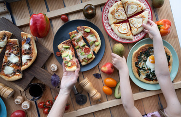 Kid and women hands take a slice of pizza