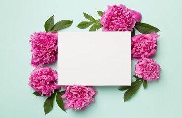 Greeting card mockup with peony flowers on color background, top view