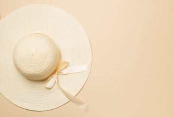 Fototapeta na wymiar Beautiful straw hat with ribbon and bow on color background, top view
