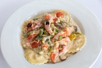 close-up of lobster ravioli with tomatoes and cream sauce