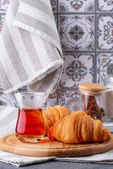 Obraz na płótnie Canvas croissant and black tea in a turkish cup