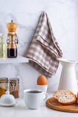 baguette, boiled egg and coffee on the kitchen table
