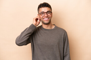 Young Brazilian man isolated on beige background laughing